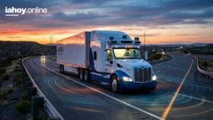 Camion autonomo de Aurora con sensores en el techo recorriendo una ruta desertica al atardecer, con los arcos de deteccion del lidar y las camaras sobre el asfalto