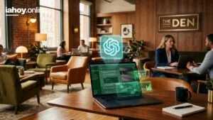 Espacio de coworking con sillones y ventanales donde la gente trabaja con notebooks, y en primer plano una notebook que muestra un panel de tareas y diagramas con el logo de OpenAI flotando en holograma sobre la pantalla